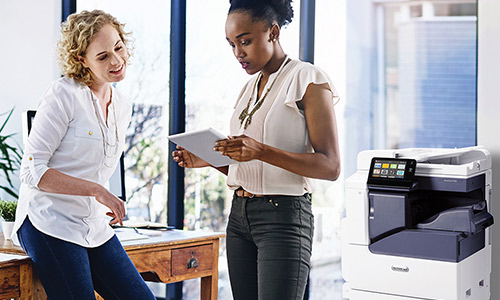 two people looking at printer paper together